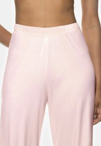 Ljust rosa, vida byxor med mjuk textur och subtila vertikala ränder. Har ett elastiskt midjeband för enkel användning.