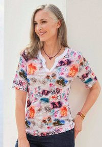 Korte mouwen top in lichte stof met een kleurrijke tropische print van palmbomen, harten en bloemenpatronen; V-hals ontwerp met witte afwerking.