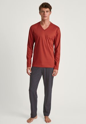 Rode lange mouwen v-hals shirt met een borstzak, gecombineerd met gestreepte pyjamabroek in het blauw, met verticale lijnpatronen.