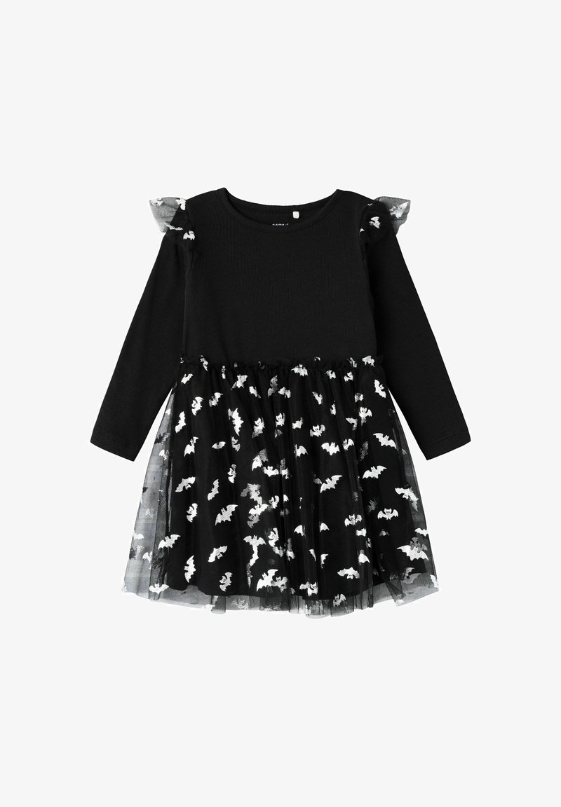 Abito nero a maniche lunghe con parte superiore uniforme. La gonna presenta un sovrapposizione di tulle trasparente con motivi di pipistrello bianchi. Le maniche arricciate aggiungono dettagli.