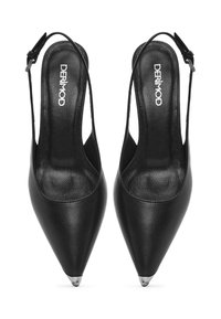 Tacchi slingback in pelle nera con punta appuntita e dettaglio in metallo sulla punta. Presentano un sottile cinturino alla caviglia per una calzata sicura.