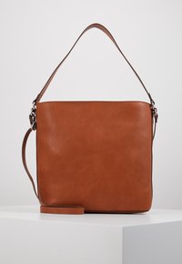 Bolso de mano de cuero marrón con textura lisa, forma rectangular, correa ajustable y diseño minimalista. Cuenta con una sola asa superior.