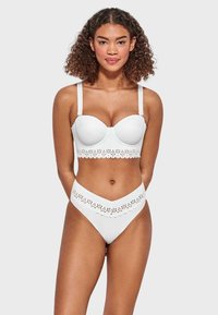 Bikini blanco de dos piezas que presenta un top estructurado estilo balconette con borde en forma de ondas y unas braguitas altas a juego con detalles recortados.