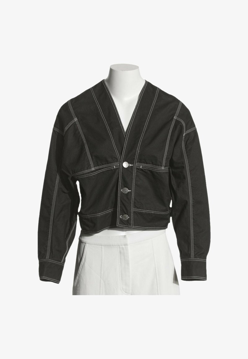 Veste noire courte avec coutures blanches, manches longues, trois boutons à l'avant et col en V, présentée sur un buste de mannequin blanc.