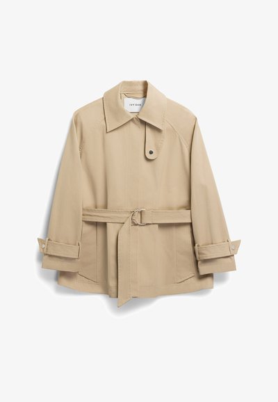 Bežs viegls jaka ar apkakli, jostu vidukli un uzrullējamiem piedurknēm. Gluda auduma ar tīru dizainu un paslēptām sānu kabatām.