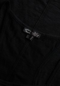 Zwarte katoenen tanktop met een ronde halslijn, dunne bandjes en een zachte, gestructureerde stof. Labels tonen merk- en maatinformatie.