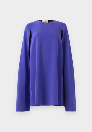 Dolga rokavica, živahno vijolične barve s širokimi, prosto visečimi rokavi, prikazana na enostavni svetlo sivi podlagi.