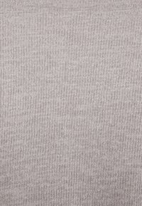 Jasnoszara, prążkowana dzianina o miękkiej teksturze, z jednolitym wzorem na całej powierzchni.