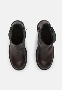 Stivaletti alla caviglia in pelle marrone scuro con una texture liscia, dettagli verdi sulla parte superiore e chiusure con zip su entrambi i lati. Design a punta rotonda.