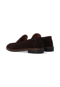 Een paar donkerbruin suède herenloafers met lage zwarte rubberen hakken, zichtbare stiksels en een instapontwerp op een witte achtergrond.