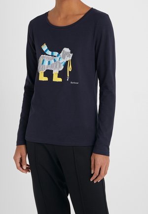 Marineblauw shirt met lange mouwen met een afbeelding van een grijze hond die een blauwgestreepte sjaal en gele laarzen draagt en een gele riem in zijn mond houdt.
