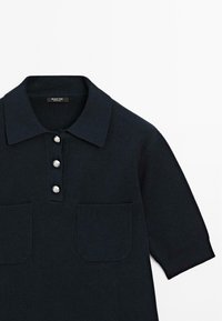 Polo shirt blu navy con maniche corte, colletto a coste e tre bottoni in argento. Presenta due tasche frontali in tessuto testurizzato.