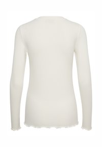 Maglia a maniche lunghe a coste in avorio, con scollo rotondo e dettagli a orlo smerlato, realizzata in un tessuto morbido ed elasticizzato.