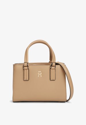 Beige leren handtas met dubbele bovenhandvatten, een afneembare schouderriem en een goudkleurig verweven "TH" logo aan de voorkant.