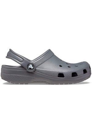 Sabot gris unique à enfiler avec des trous de ventilation, une semelle texturée et une bride de talon réglable avec un bouton logo sur fond blanc.