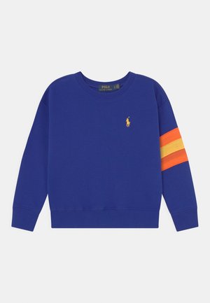 Sudadera azul real hecha de una tela suave, con un pequeño logo amarillo y franjas naranjas y amarillas en la manga izquierda.