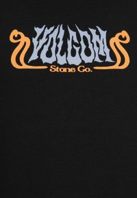 Sort t-shirt med et stiliseret, flerfarvet logo. Teksten siger "VOLCOM Stone Co." i blå og orange, med en blød og glat stoftekstur.