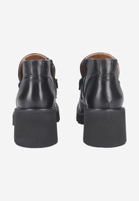 Schwarze Leder-Ankelboots mit runder Form, seitlichen Reißverschlüssen und klobigen Gummifellen. Glatte Textur mit minimalen Hardware-Akzenten.