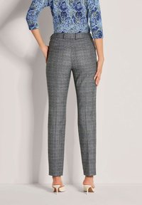 Grijze geruite broek met een taillerende pasvorm, gladde textuur en een mid-rise taille, gecombineerd met off-white hakken.