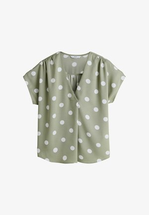 Grüne Bluse mit weißen Polka-Dots, V-Ausschnitt, kurzen Ärmeln und Raffdetail am Rücken. Hergestellt aus leichtem Stoff.