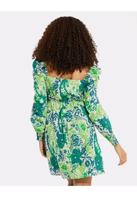 Abito a stampa floreale in tonalità di verde e blu. Presenta maniche a sbuffo, schiena quadrata e una vita elastica per un look aderente.