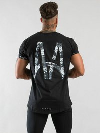 Svart T-shirt med ett stort, vitt blommönster på ryggen och texten "LIMITÉ" i vitt vid nederkanten. Korta ärmar.