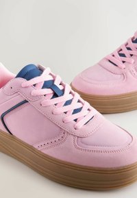 Baskets en daim rose avec des accents bleus, dotées de lacets plats, d'une languette rembourrée et d'une semelle en caoutchouc marron. Bout arrondi avec des détails perforés.