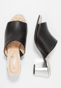 Svarta öppna sandaler med tå, gjorda av texturerat läder, med en rund silverklossklack och en stoppad beige innersula med subtil branding.