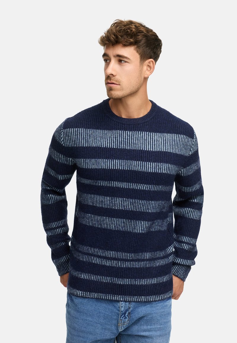 Mørkeblå sweater med horisontale striber i lys blå. Ribbet tekstur, rund hals og lange ærmer. Sammen med lys blå jeans.