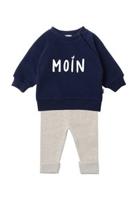 Navy blue sweatshirt with white "MOIN" lettering on the front, paired with light beige ribbed sweatpants featuring rolled cuffs.