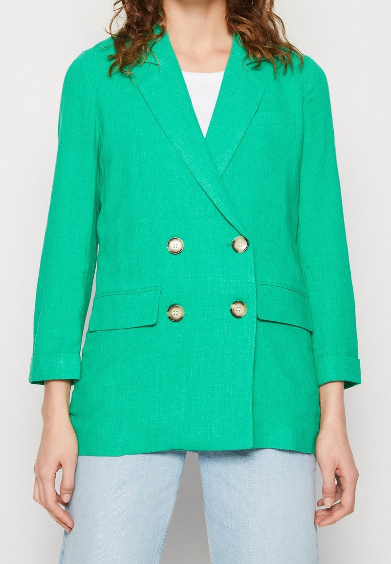 Zelený lněný dvouřadý blazer se dvěma velkými zlatými knoflíky, dvěma předními kapsami, klopami a ohrnutými rukávy.