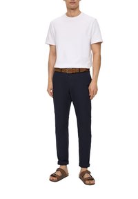 Weißes Baumwoll-T-Shirt, marineblaue maßgeschneiderte Hose, brauer Leder-Gürtel und braune Sandalen. Einfaches Design, lässiger Schnitt und neutrale Farben.