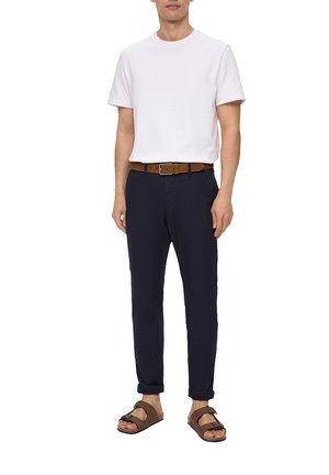 Weißes Baumwoll-T-Shirt, marineblaue maßgeschneiderte Hose, brauer Leder-Gürtel und braune Sandalen. Einfaches Design, lässiger Schnitt und neutrale Farben.