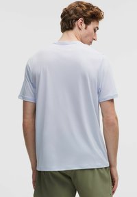 Lichtblauw sportshirt met korte mouwen, ronde hals en een zachte, gladde textuur. Eenvoudig ontwerp, geschikt voor sport of casual gebruik.