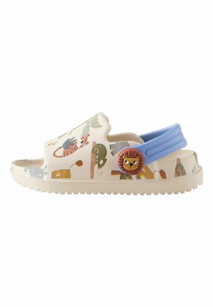 Children’s cream slip-on sandal with blue heel strap and printed cartoon jungle animals, including lions and chameleons.