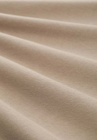 Material bej expus în pliuri ondulate; textură netedă cu un luciu subtil și un model de țesătură constant.