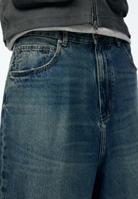 Haaleansiniset farkut, rento istuvuus, perinteisellä viiden taskun mallilla ja kontrastiniiilauksella saumoissa.