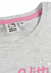 T-shirt in cotone grigio con colletto rosa e etichetta "Hello Kitty". Presenta testo rosa e motivi a stella sul davanti.