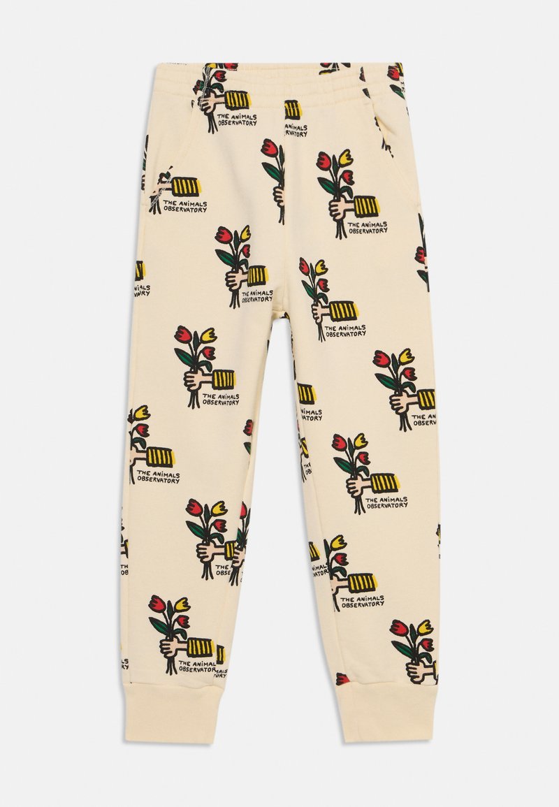 Cream-colored pants made of soft fabric, featuring a repeated whimsical pattern of hands holding flowers and a striped object. Includes pockets.