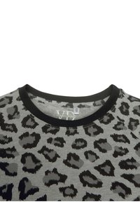 Grå T-shirt med svart leopardmönster, med svart ribbad rundhals och etikett, tillverkad av mjukt tyg.