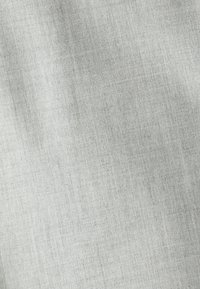 Tejido gris claro con textura sutil y arrugas suaves, mostrando un patrón de material tejido similar al lino.