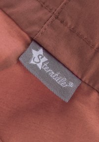 Rostfarbener Stoff mit glatter Textur, versehen mit einem grauen Etikett, auf dem der Markenname "Sterntaler" in weißen Buchstaben und ein Sternlogo abgebildet ist.