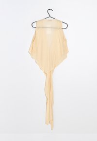 Beige, lätt topp med öppna axlar, djup V-hals och draperad fåll. Den har ett långt, svävande band vid botten.