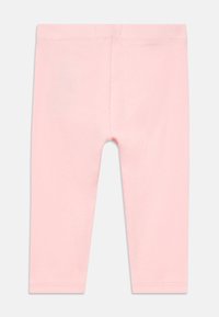 Ružové rebrované legíny s jemnou textúrou, ktoré majú pohodlný pás a bez viditeľných švov alebo ozdôb.