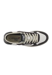 Sneaker bianca e marrone scuro con tomaia in camoscio, punta perforata e accenti a contrasto. Presenta lacci piatti e un logo sulla linguetta.