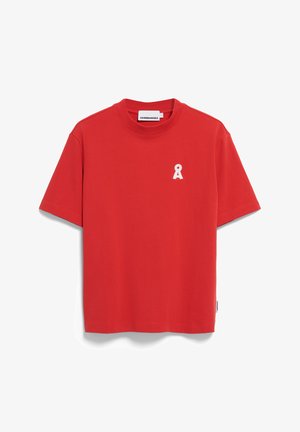Camiseta de algodón roja con cuello redondo, mangas cortas y un pequeño logo de cinta blanca en el lado izquierdo del pecho. Textura suave, diseño casual.