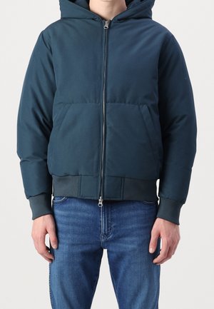 Navy blue padded jacket with a hood, front zipper, and two large pockets. Features ribbed cuffs and hem for a fitted look.