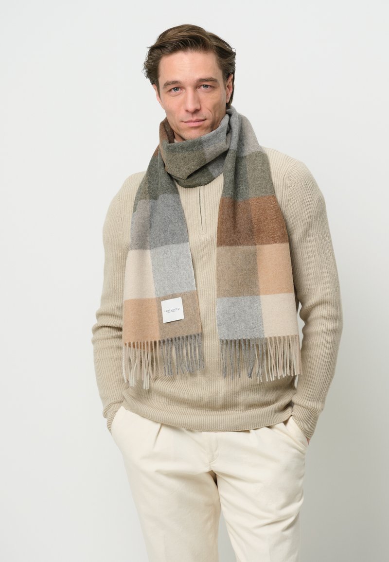 Uld tørklæde i et rute-mønster med grå, beige og brune nuancer. Afsluttet med frynset kanter og en lille etiket på den ene side.