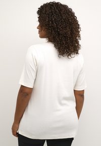 White short-sleeve t-shirt made of soft, ribbed fabric. Features a round neckline and a relaxed fit, with a smooth texture.