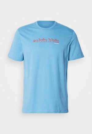 Helles blaues Baumwoll-T-Shirt mit kurzen Ärmeln und rundem Ausschnitt, das mittig auf der Brust mit einem auffälligen "calvin klein"-Logo in Rot bedruckt ist.